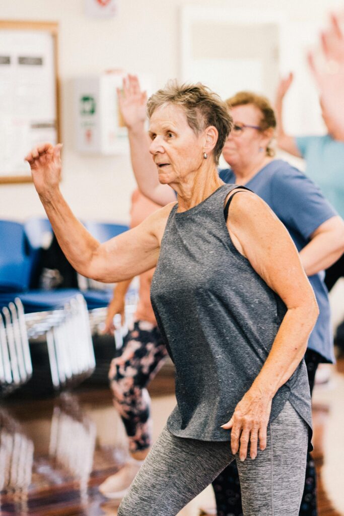 Group of senior women dancing energetically in a fitness class promoting a healthy lifestyle.